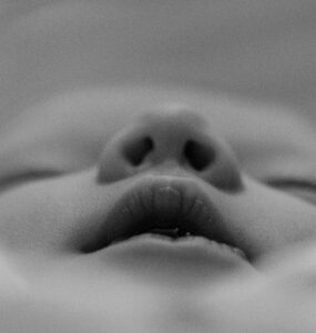 La cara de un infante dormiendo, tomada desde una persepctiva extraña, evocas sensaciones de cielos y planetas