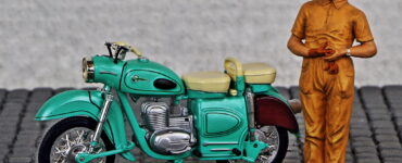 Modelo de la motocicleta MZ ES 250 con el muñeco de u conductor al lado. Portada de homenaje poético a las motocicletas