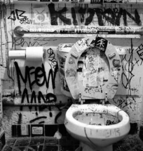 Una toilette sucia, llena de escritas y malos olores