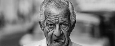 Despedida cuentos retrato de un escritor anciano caminando con boca abierta y mostrando la lengua