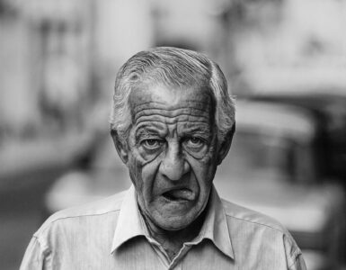 Despedida cuentos retrato de un escritor anciano caminando con boca abierta y mostrando la lengua
