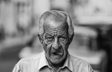 Despedida cuentos retrato de un escritor anciano caminando con boca abierta y mostrando la lengua