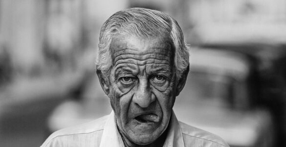 Despedida cuentos retrato de un escritor anciano caminando con boca abierta y mostrando la lengua