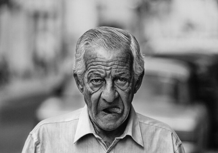 Despedida cuentos retrato de un escritor anciano caminando con boca abierta y mostrando la lengua